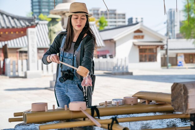 jolie femme se lavant les mains pour nettoyer et purifier avant d'aller au sanctuaire.