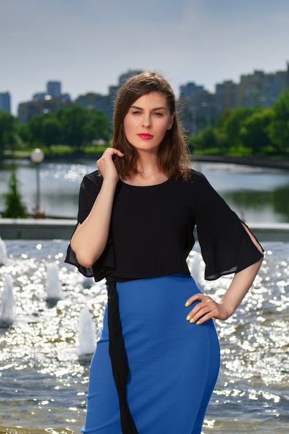 Jolie femme se reposant près de la fontaine