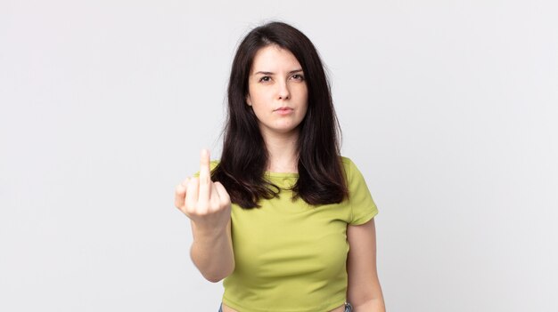 Jolie femme se sentant en colère, agacée, rebelle et agressive, retournant le majeur, ripostant