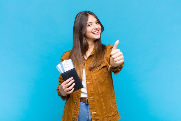 Jolie femme se sentant fière, insouciante, confiante et heureuse, souriant positivement avec les pouces vers le haut