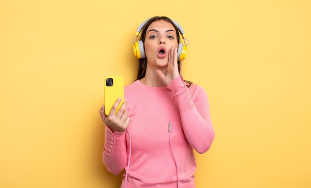 Jolie femme se sentant heureuse, donnant un grand cri avec les mains à côté de la bouche. concept d'écoute de musique