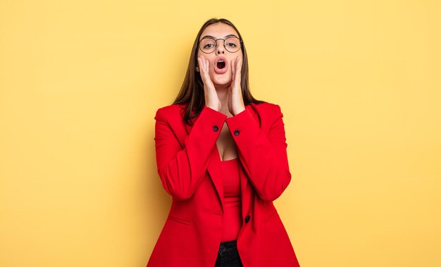 Jolie femme se sentant heureuse, donnant un grand cri avec les mains à côté de la bouche. notion de femme d'affaires