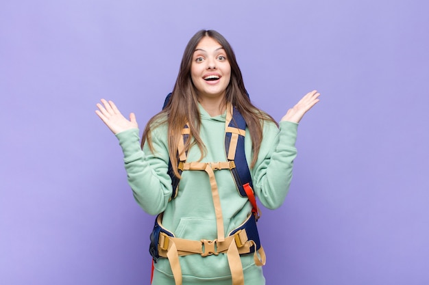 Jolie femme se sentant heureuse, excitée, surprise ou choquée, souriante et étonnée de quelque chose d'incroyable