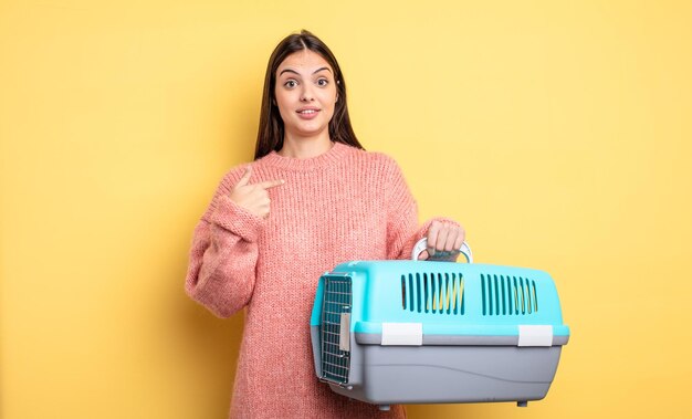 Jolie femme se sentant heureuse et pointant vers soi avec un excité. concept de transporteur pour animaux de compagnie