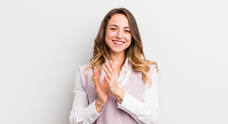 Photo jolie femme se sentant heureuse et réussie en souriant et en frappant des mains en disant félicitations avec des applaudissements