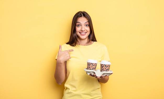 Jolie femme se sentant heureuse et se montrant elle-même avec une excitation. concept de café à emporter