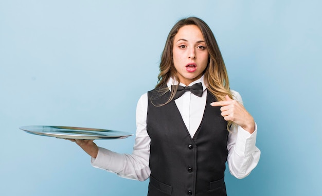 Jolie femme semblant choquée et surprise avec la bouche grande ouverte pointant vers soi