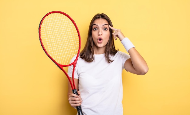 Jolie femme semblant surprise, réalisant une nouvelle pensée, idée ou concept. concept de joueur de tennis