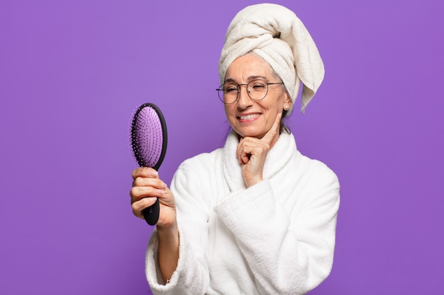 Jolie femme senior avec une brosse à cheveux