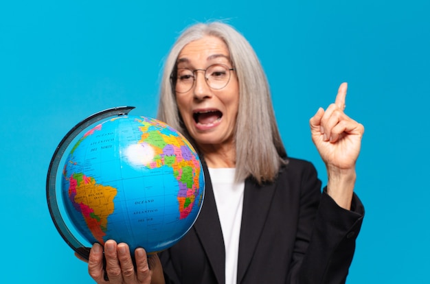 Jolie femme senior avec un globe terrestre