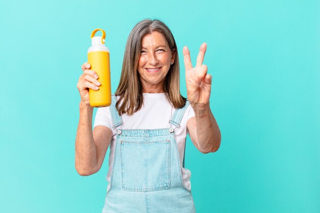 Jolie femme senior avec un thermos de café