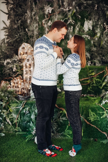 Jolie femme avec son mari se tiennent la main avec différentes décorations de Noël