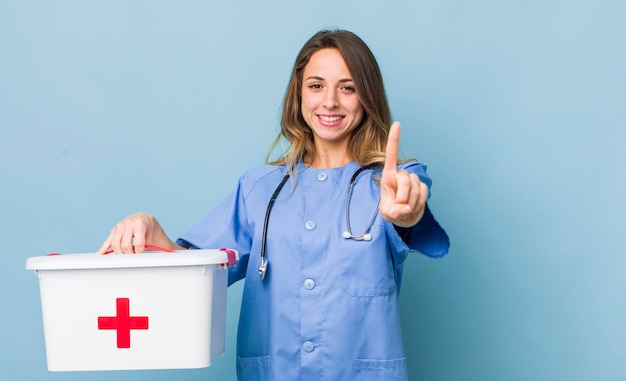 Jolie femme souriant fièrement et en toute confiance faisant le numéro un