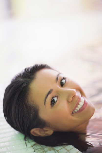 Jolie femme souriante allongée dans un jacuzzi