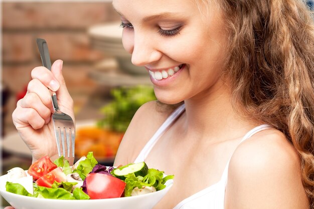 Jolie femme souriante caucasienne avec salade isolée