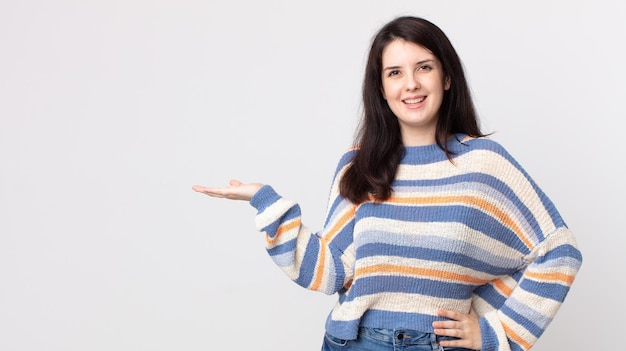 Jolie femme souriante, confiante, réussie et heureuse, montrant un concept ou une idée sur l'espace de copie sur le côté