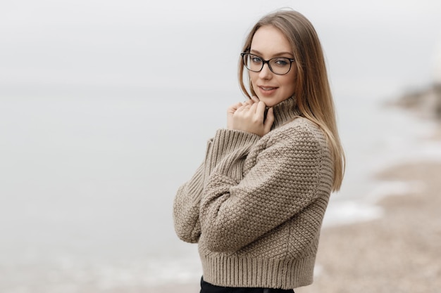 jolie femme souriante confortable en plein air près de la mer