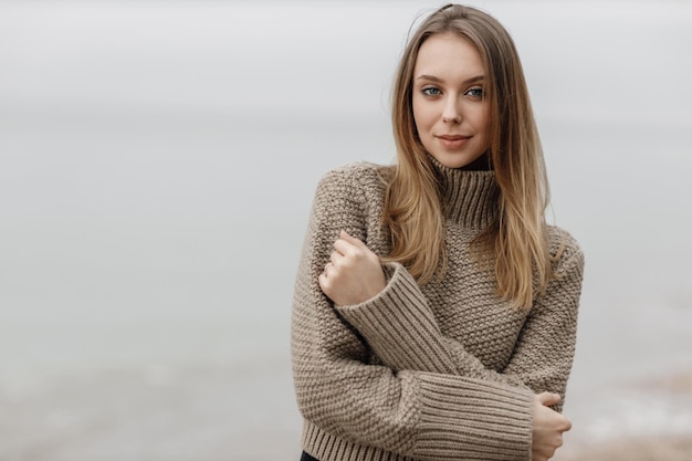 jolie femme souriante confortable en plein air près de la mer