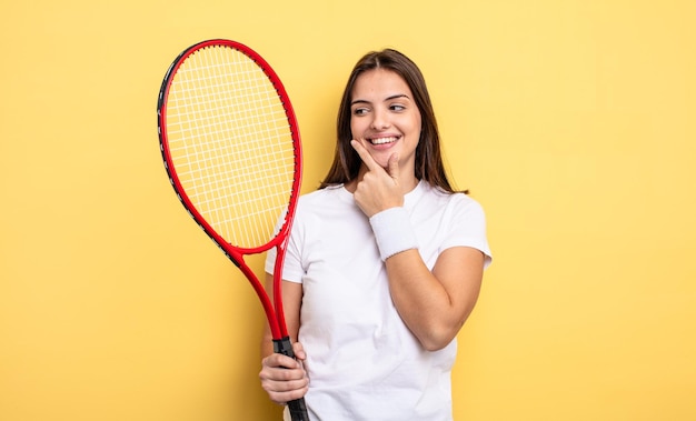 Jolie femme souriante avec une expression heureuse et confiante avec la main sur le menton. notion de joueur de tennis