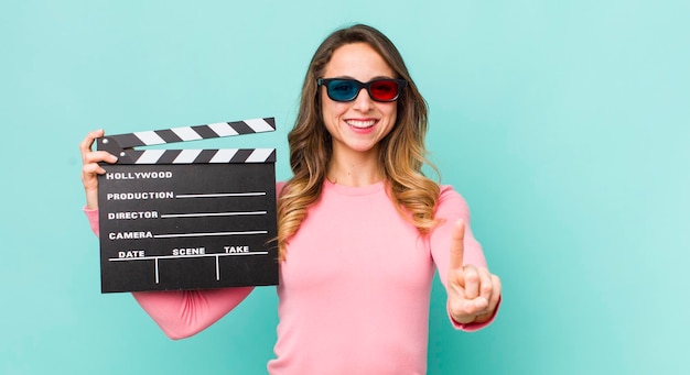 Jolie femme souriante fièrement et avec confiance faisant le numéro un