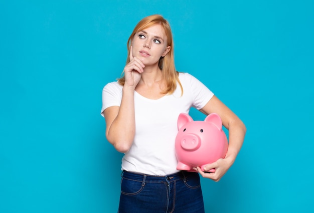 Jolie femme souriante joyeusement et rêvant ou doutant, regardant sur le côté