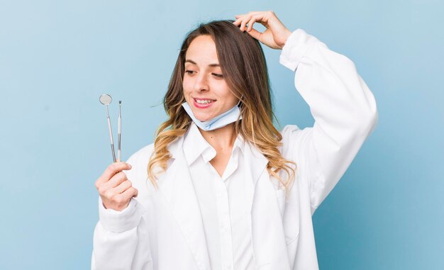 Jolie femme souriante joyeusement et rêvasser ou douter