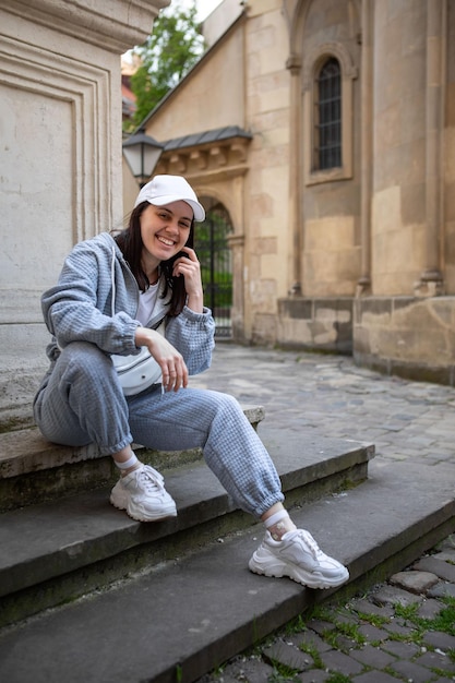 Jolie femme souriante posant dans un tissu de sport baggy à l'extérieur