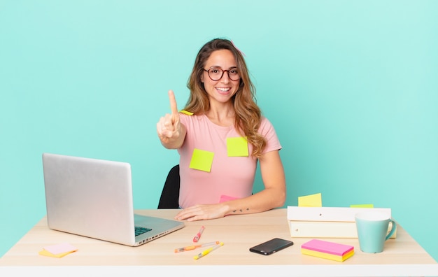 Jolie femme souriante et semblant amicale, montrant le numéro un. concept de télétravail