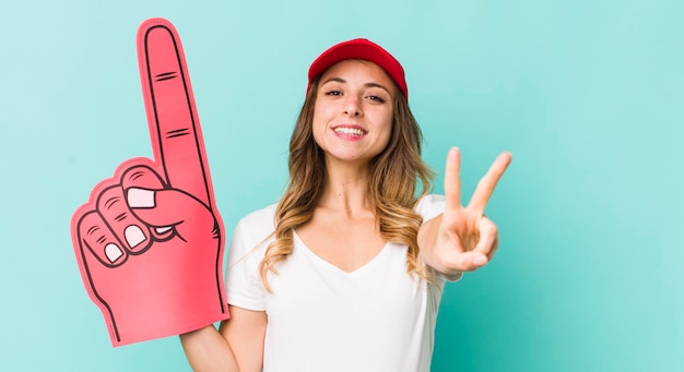 Jolie femme souriante et semblant heureuse gesticulant victoire ou paix