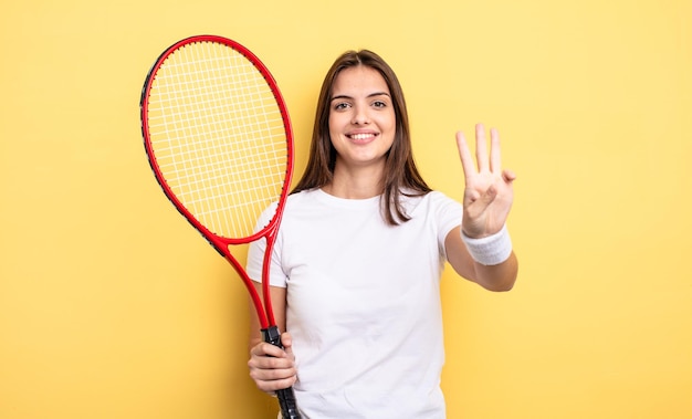 Jolie femme souriante et sympathique, montrant le numéro trois. notion de joueur de tennis