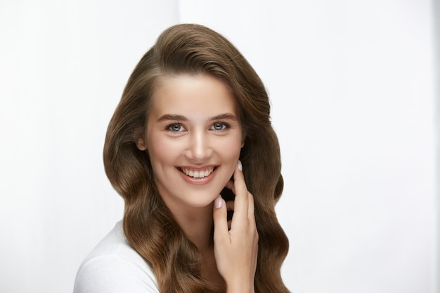 Jolie femme avec un sourire de luxe et des cheveux longs en bonne santé