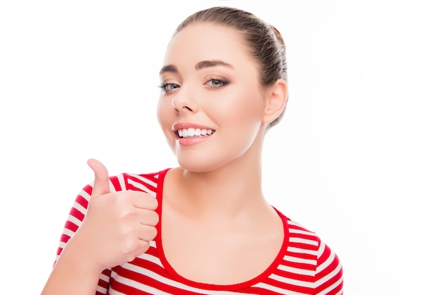 Jolie femme avec un sourire rayonnant montrant le pouce vers le haut