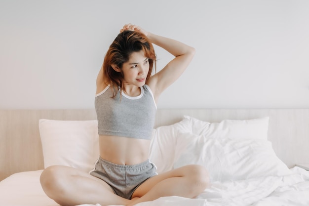 Jolie femme en sous-vêtements qui s'étend sur le lit le matin