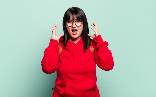 Jolie femme taille plus criant avec les mains en l'air