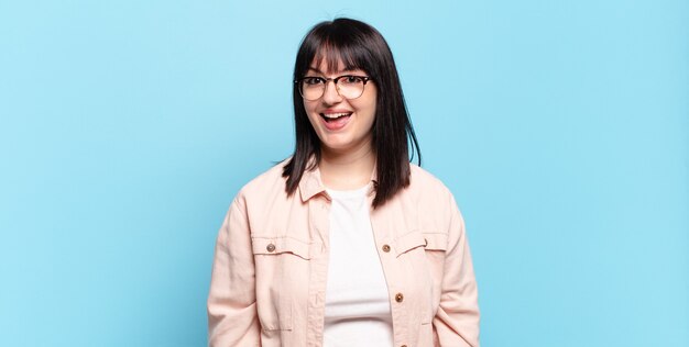 Jolie femme taille plus avec un grand sourire amical et insouciant, l'air positif, détendu et heureux, effrayant