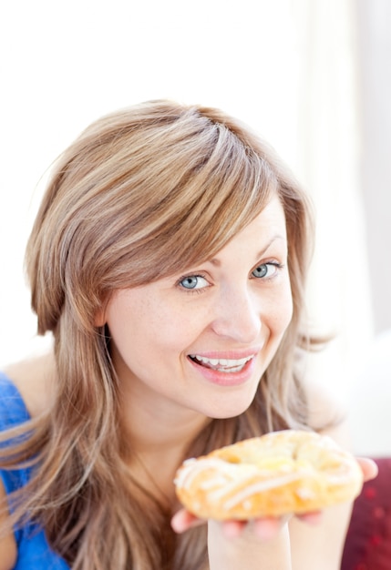 Jolie femme tenant une pâtisserie danois