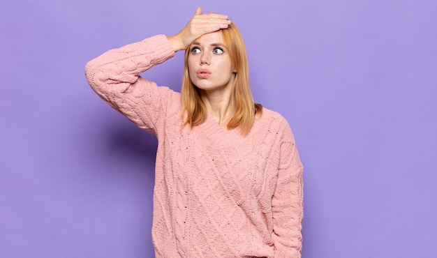 Jolie femme à tête rouge paniquant sur une date limite oubliée, se sentant stressée, devant couvrir un gâchis ou une erreur