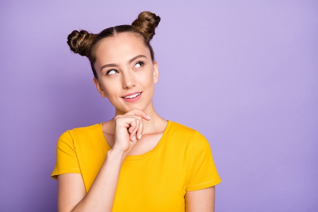 Jolie femme avec topknots posant contre le mur violet