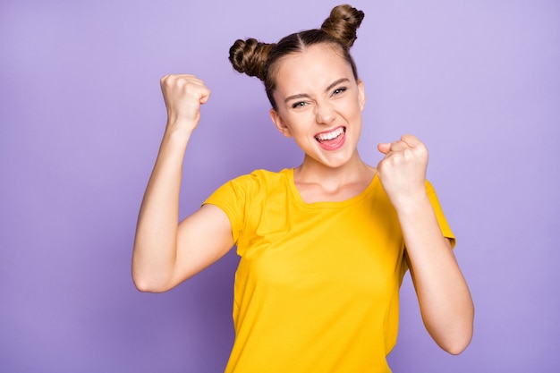 Jolie femme avec topknots posant contre le mur violet