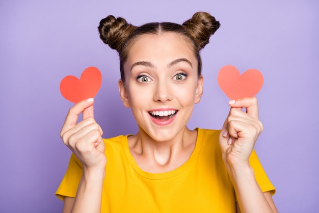 Jolie femme avec topknots posant contre le mur violet