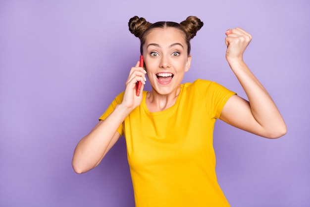 Jolie femme avec topknots posant contre le mur violet