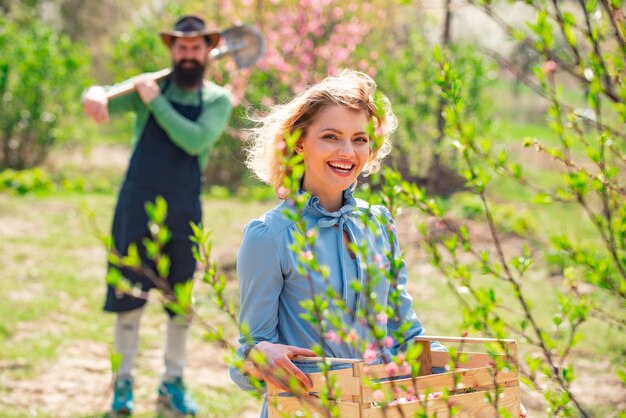 Jolie femme travaillant et jouant dans un beau jardin Belle femme sur fond de fleurs un jour de printemps Femme plantant des fleurs