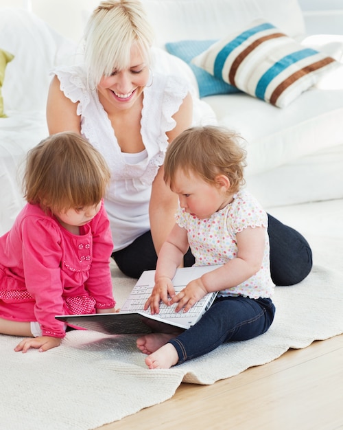 Jolie femme travaillant avec ses enfants à l&#39;ordinateur portable