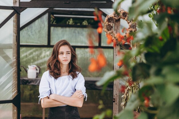 Jolie fille de 13 ans portant un panier de belle fleur dans le champ de fleurs avec bonheur