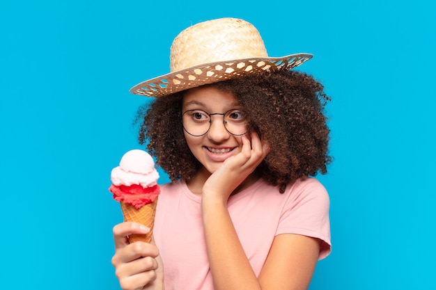 Jolie fille adolescente afro avec un chapeau et une glace. concept d'été