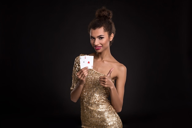 Une jolie fille africaine montre deux as au poker de casino et gagne