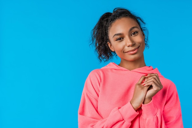 Jolie fille africaine souriante sur fond bleu