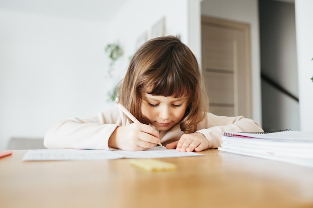 Jolie fille d'âge préscolaire apprenant à la maison l'enseignement à distance pour les enfants