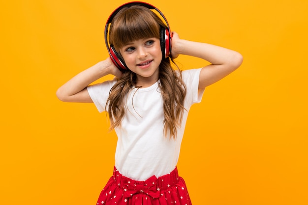 Jolie fille aime écouter de la musique sur les écouteurs sur orange