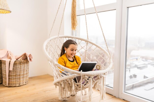 Jolie fille allongée sur un canapé avec tablette.